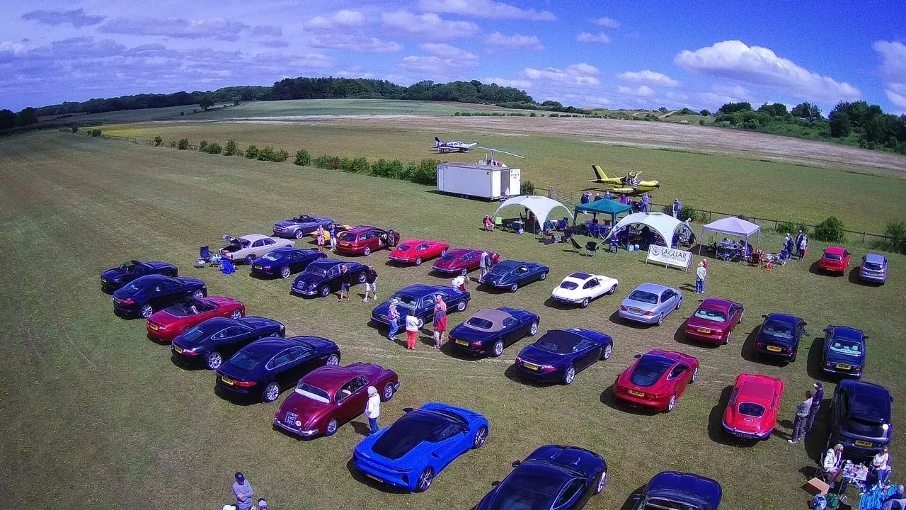 Members' Jaguars parked in rows at Popham Airfield, seen from the air